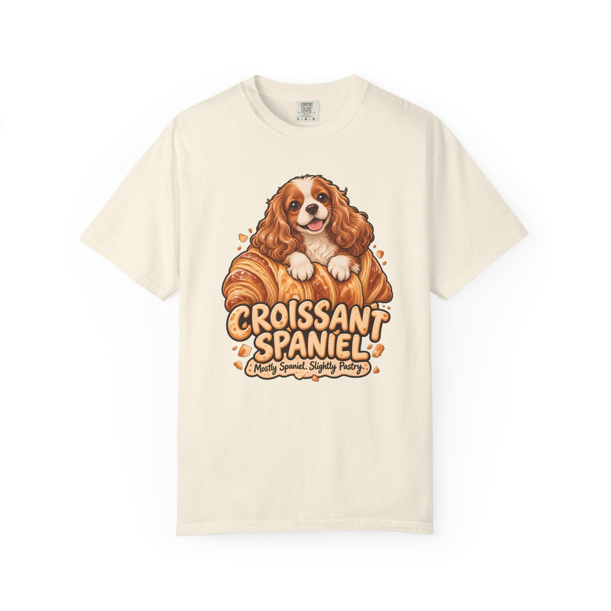 Ivory Croissant Spaniel T-shirt, featuring a Cavalier spaniel combined with a golden croissant and the wording “Croissant Spaniel — Mostly Spaniel. Slightly Pastry.”