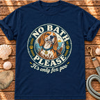 A navy blue short-sleeve t-shirt with a circular graphic of a beagle dog and the text 'NO BATH PLEASE It's only fox poo', laid flat on a rustic wooden background with seashells and a leash nearby.