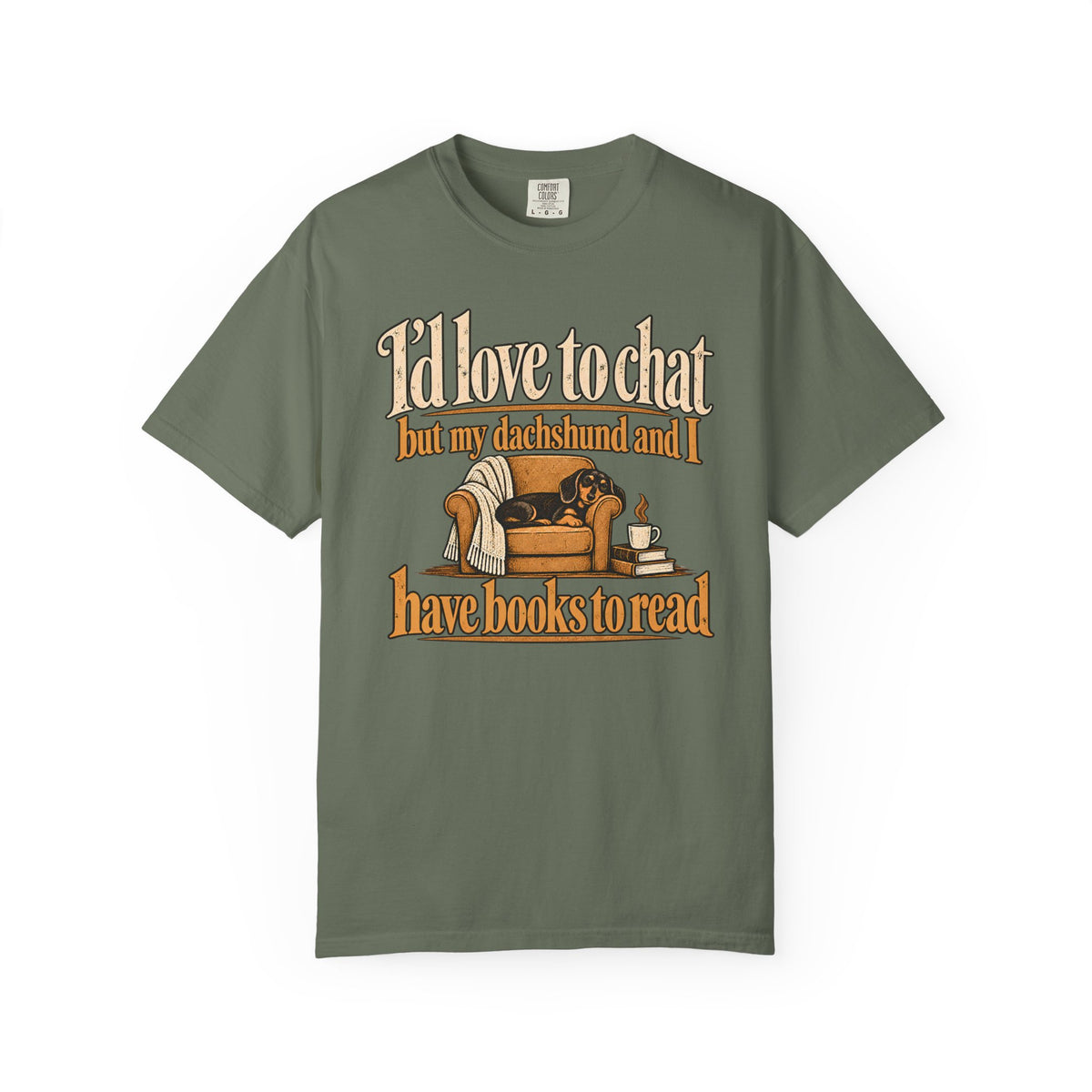 Front of a Moss T-shirt with the dachshund, armchair and books illustration with “I’d love to chat” lettering.