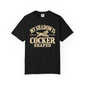 Front of a dark T-shirt with the Cocker Spaniel illustration and “My shadow is cocker shaped” lettering.