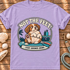 Front view of a Brinehound T-shirt showing a dog on a grooming table beneath Not the Feet lettering.