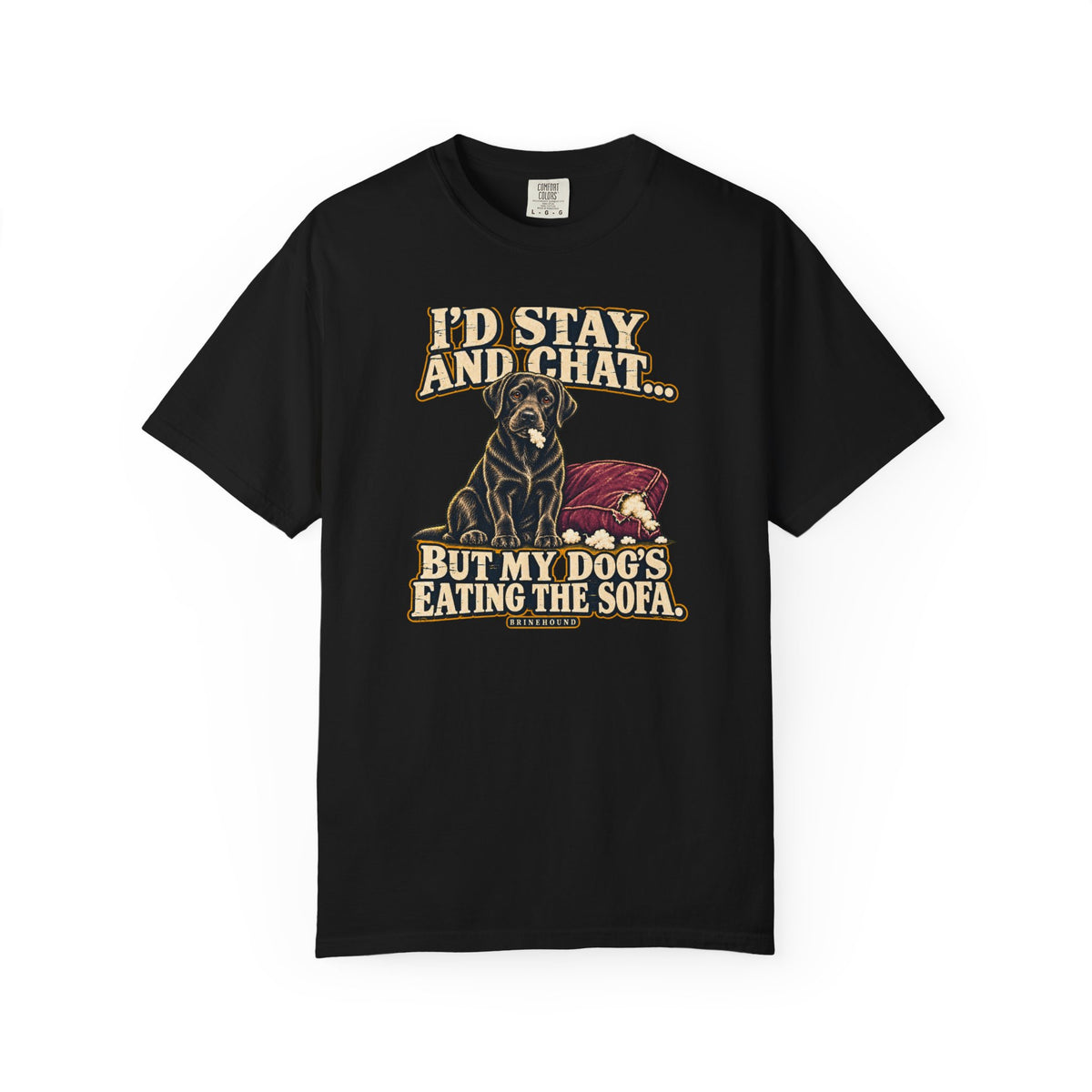 Front of a Black T-shirt with a vintage black Labrador beside a chewed sofa and “I’d stay and chat” lettering print.