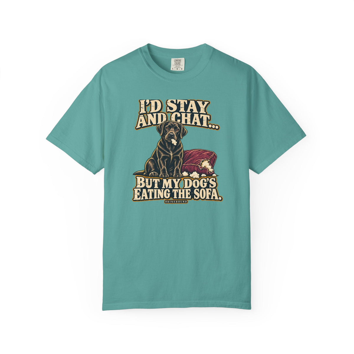 Front of a Seafoam T-shirt with a vintage black Labrador beside a chewed sofa and “I’d stay and chat” lettering print.