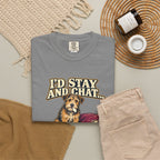 Grey T-shirt with the scruffy terrier beside a chewed sofa and “I’d stay and chat” lettering print, styled with beige trousers and coffee.