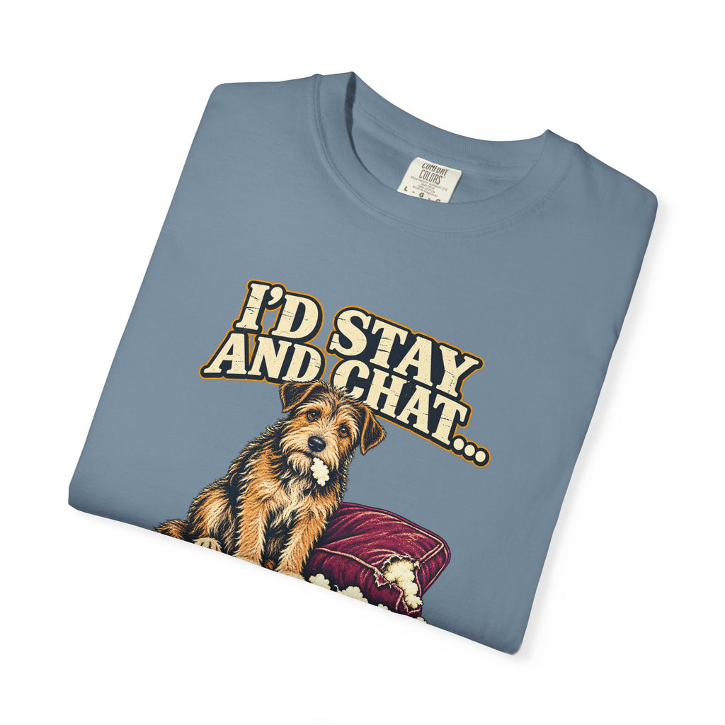Folded Ice Blue T-shirt showing a close-up of the scruffy terrier beside a chewed sofa and “I’d stay and chat” lettering print.