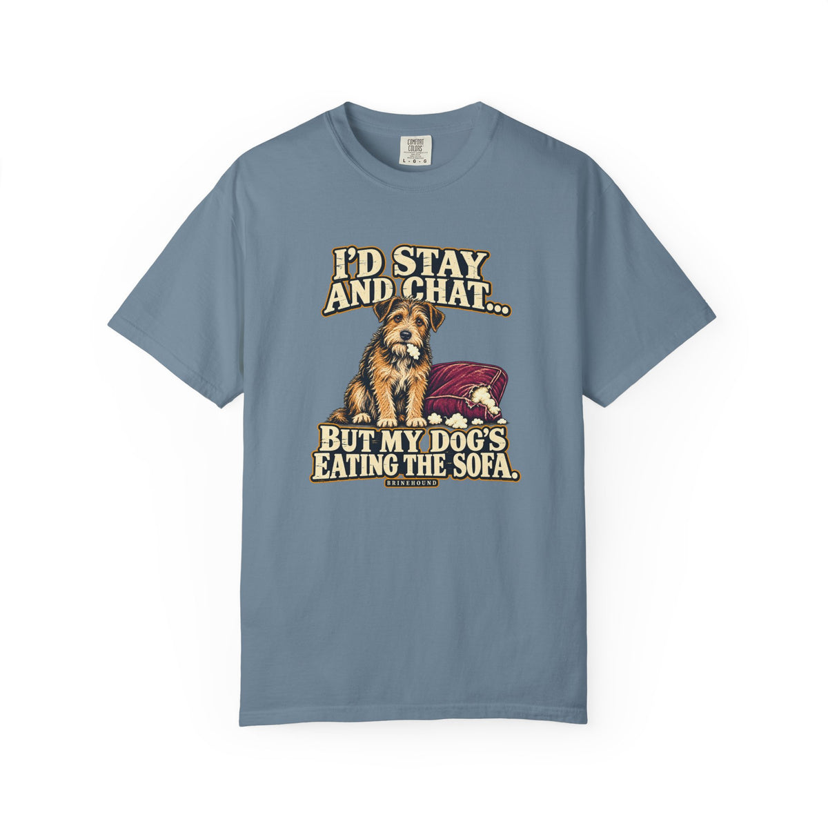 Front of a Ice Blue T-shirt with a vintage scruffy terrier beside a chewed sofa and “I’d stay and chat” lettering print.