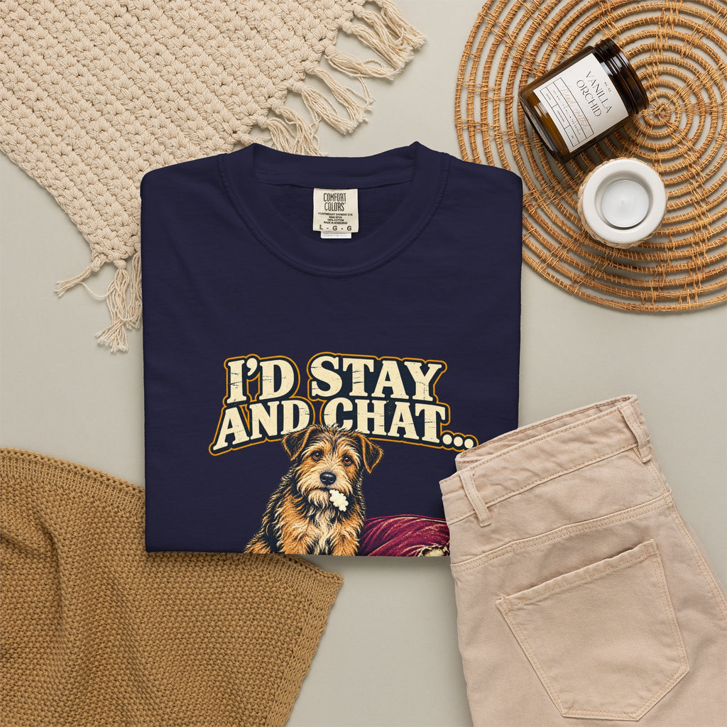 True Navy T-shirt with the scruffy terrier beside a chewed sofa and “I’d stay and chat” lettering print, styled with beige trousers and coffee.